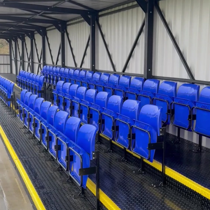 Custom Sports Seating Rows of blue stadium seats arranged in a covered stand.